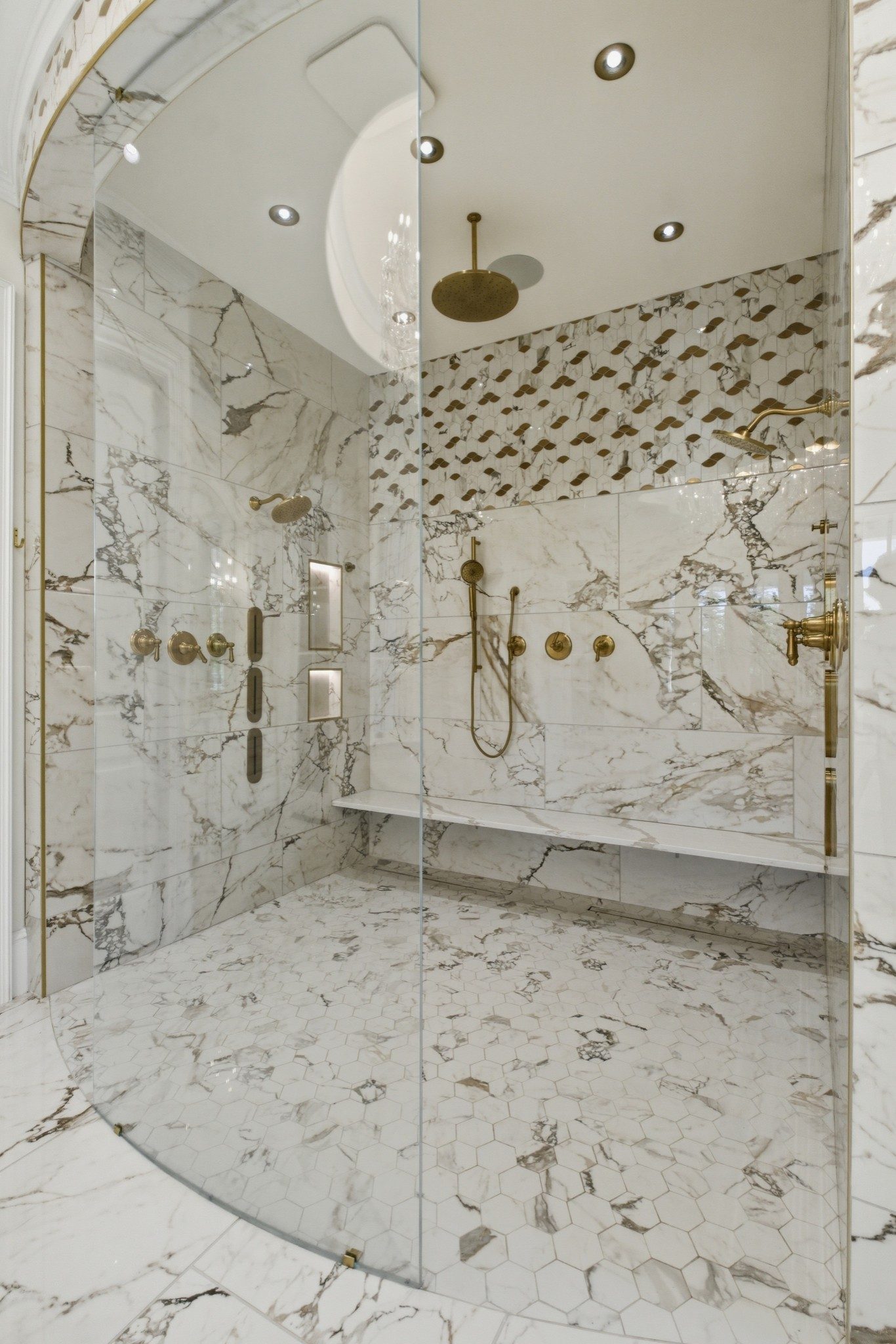 The spa bath in the primary suite, with a glass walk in shower